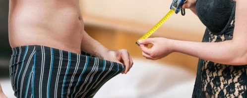 Uma mulher mede o comprimento de um homem de um homem